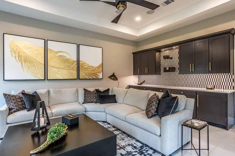 Modern living room with gray sectional, black coffee table, wall art, and built-in cabinets