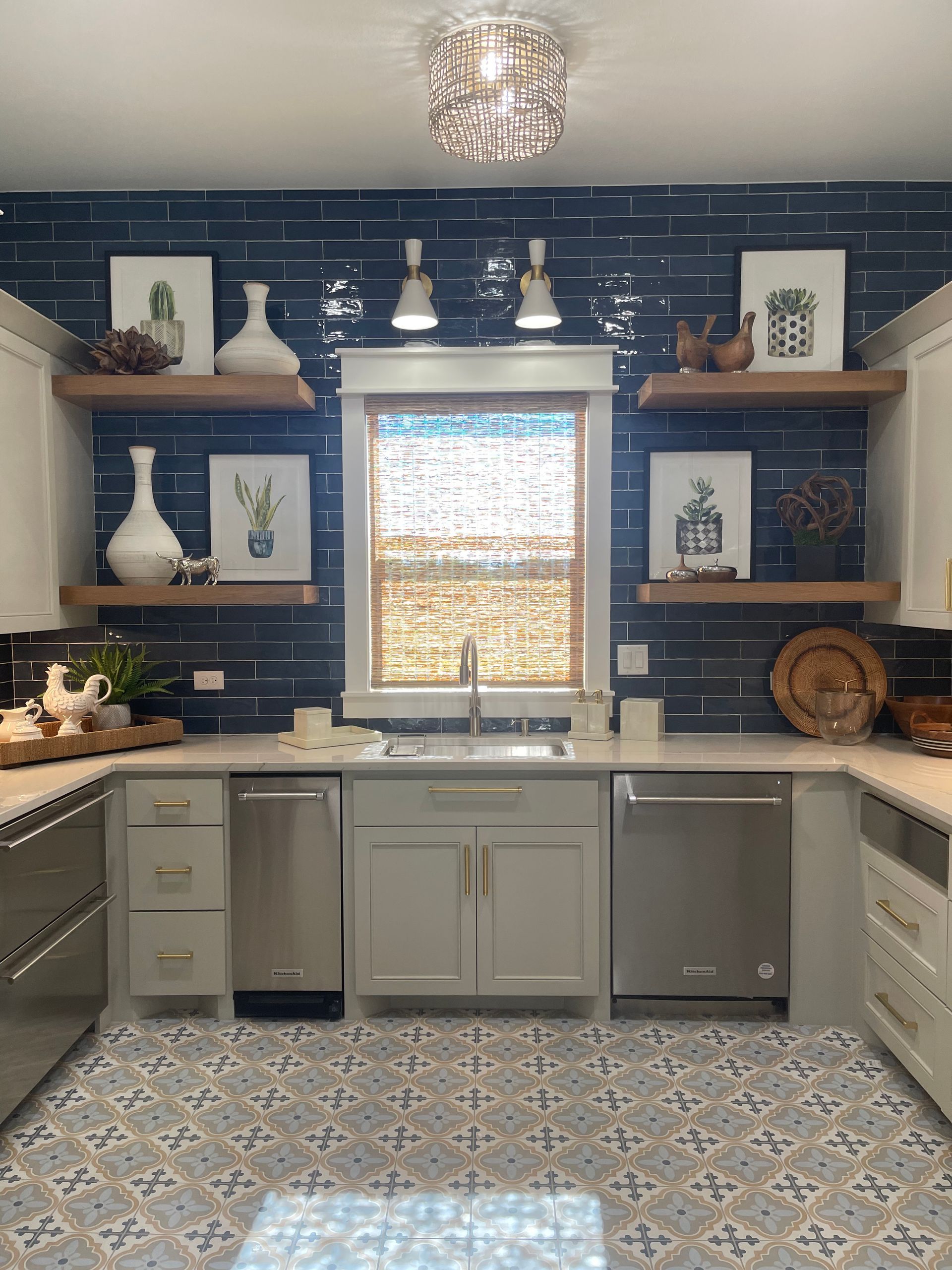 Blue kitchen with open shelves, white cabinets, patterned floor, and a window over the sink