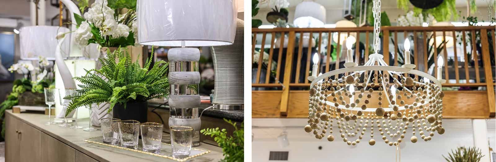 Elegant table centerpiece with white lanterns, greenery, and a gold chandelier on a display table