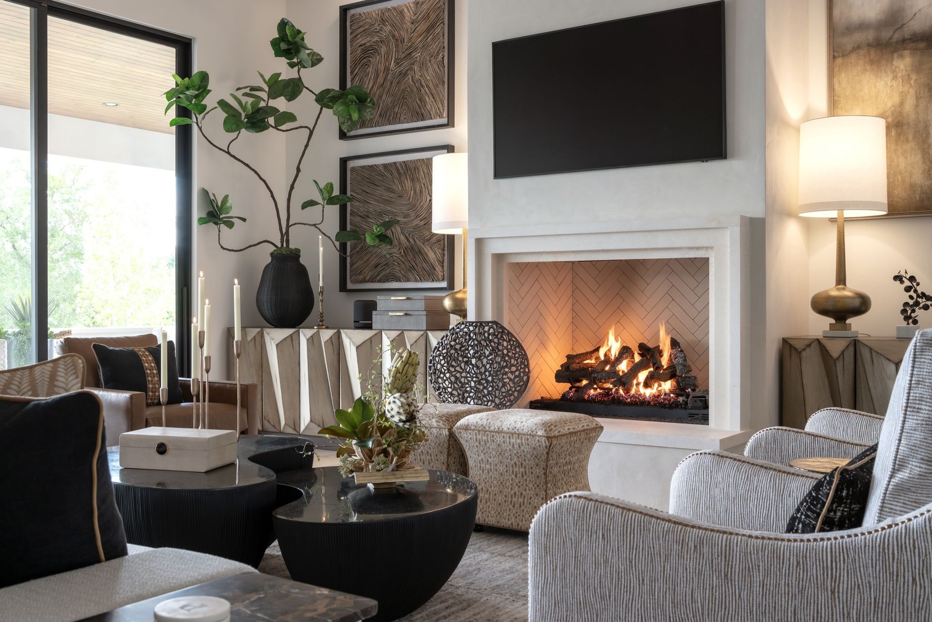 Modern living room with fireplace, TV, large windows, and black-and-white seating and decor