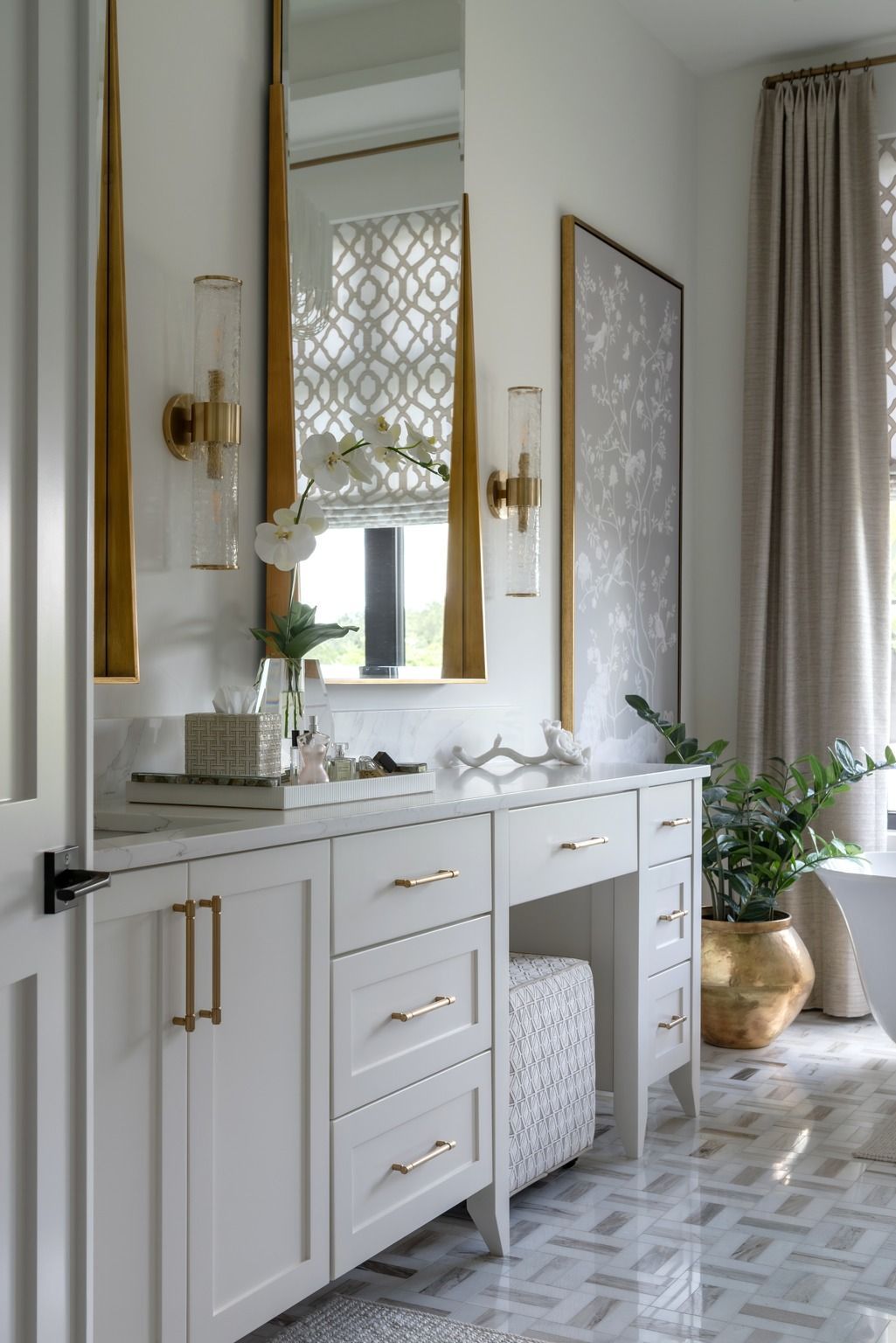 White vanity with gold accents and mirror in a bright bedroom
