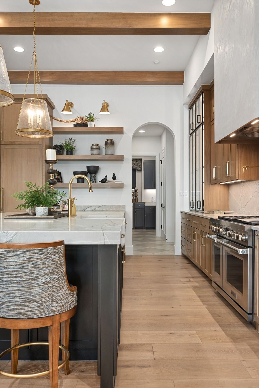 Modern kitchen with wood beams, white cabinets, open shelves, and stainless steel appliances