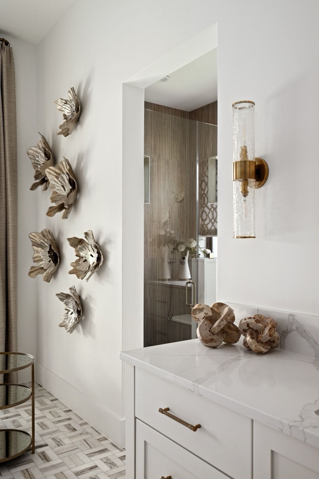 Bright hallway with white console, gold wall decor, mirror, and decorative branches on a light rug