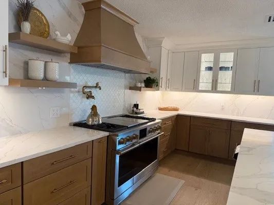 Modern kitchen with white cabinets, wood lower cabinets, stainless stove, and a window above the sink