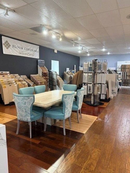 Furniture showroom with tables, chairs, and display racks on a wood floor