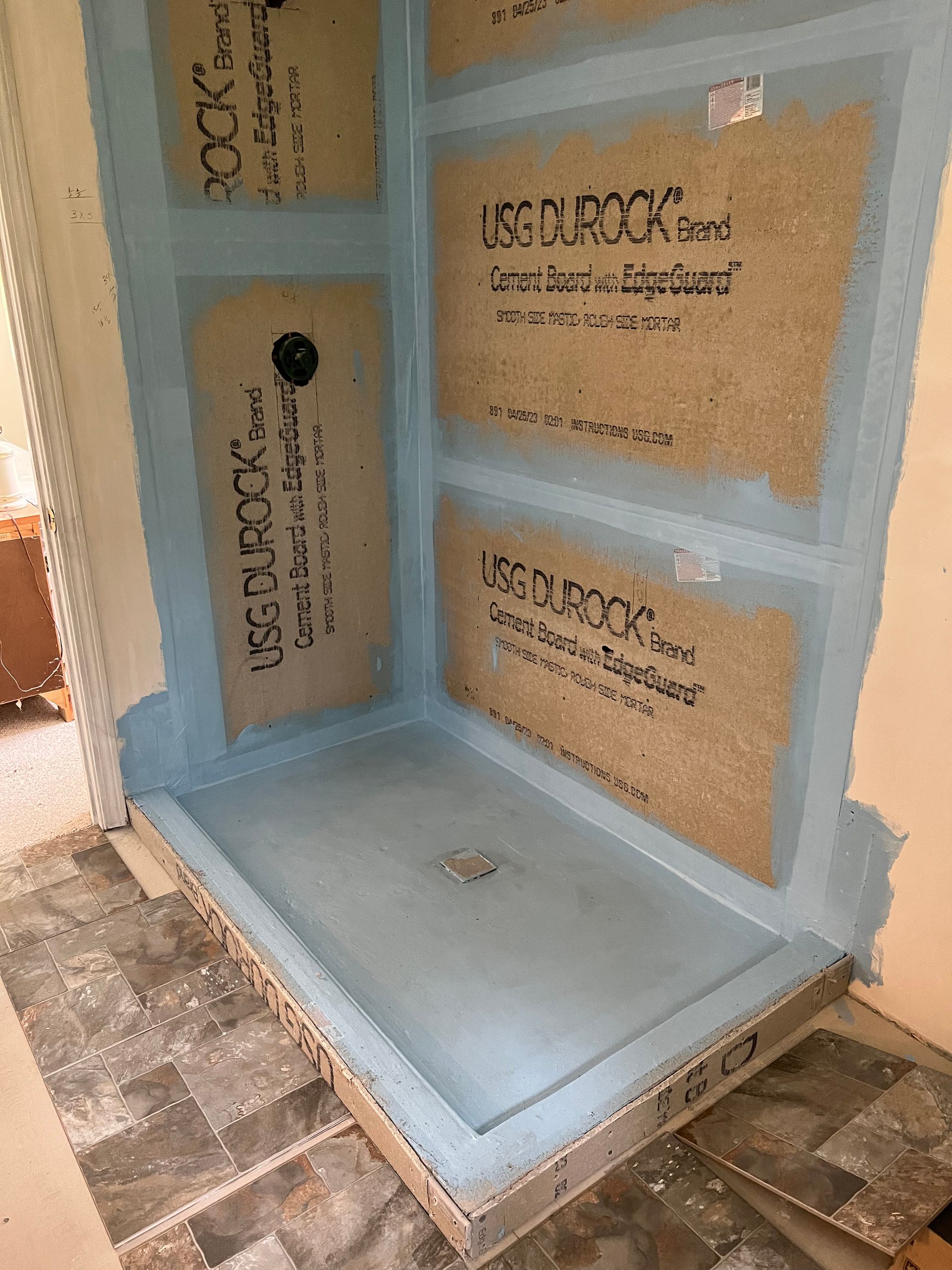 A shower stall is being built in a bathroom.