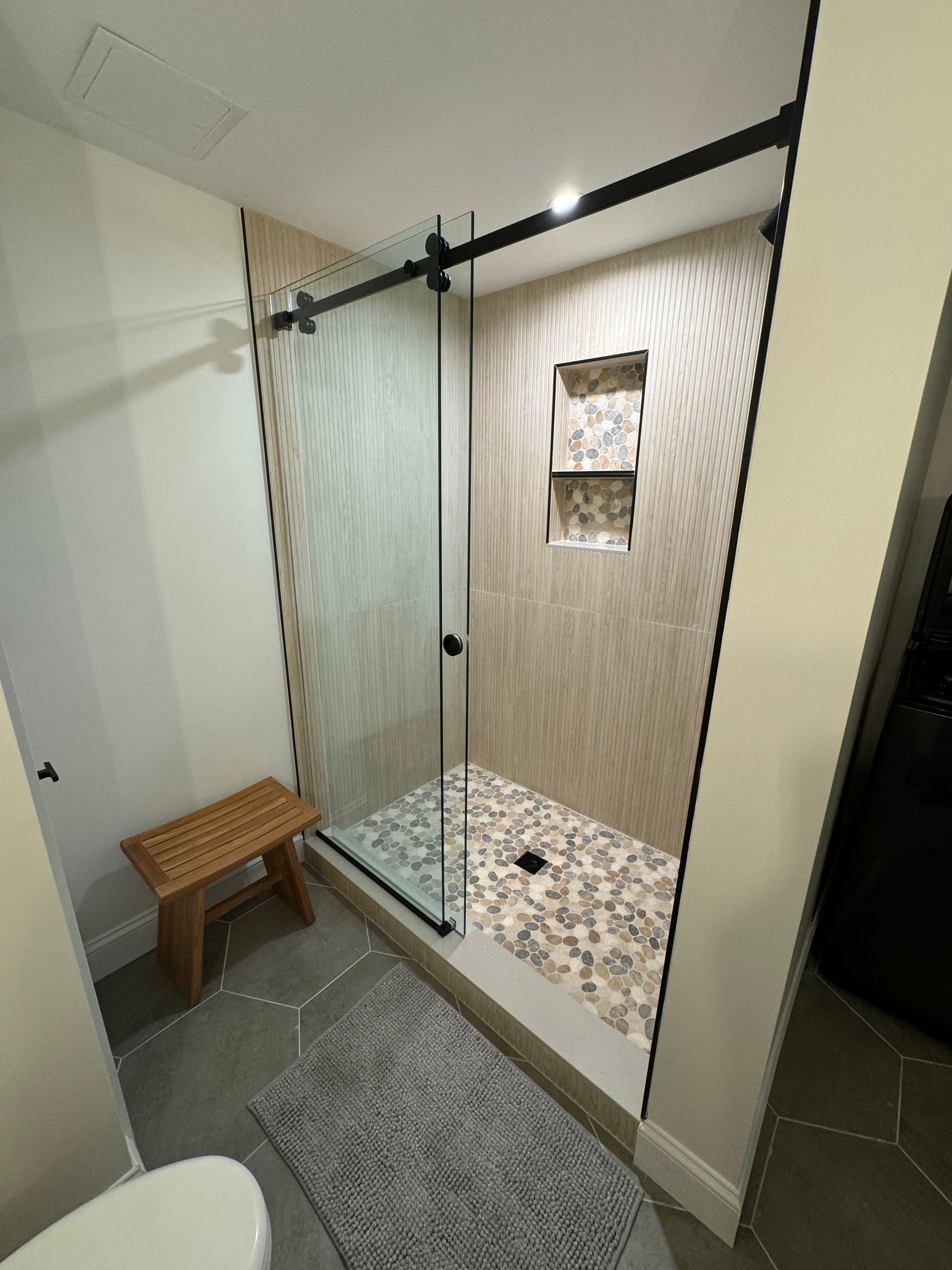 A bathroom with a walk in shower and a toilet.