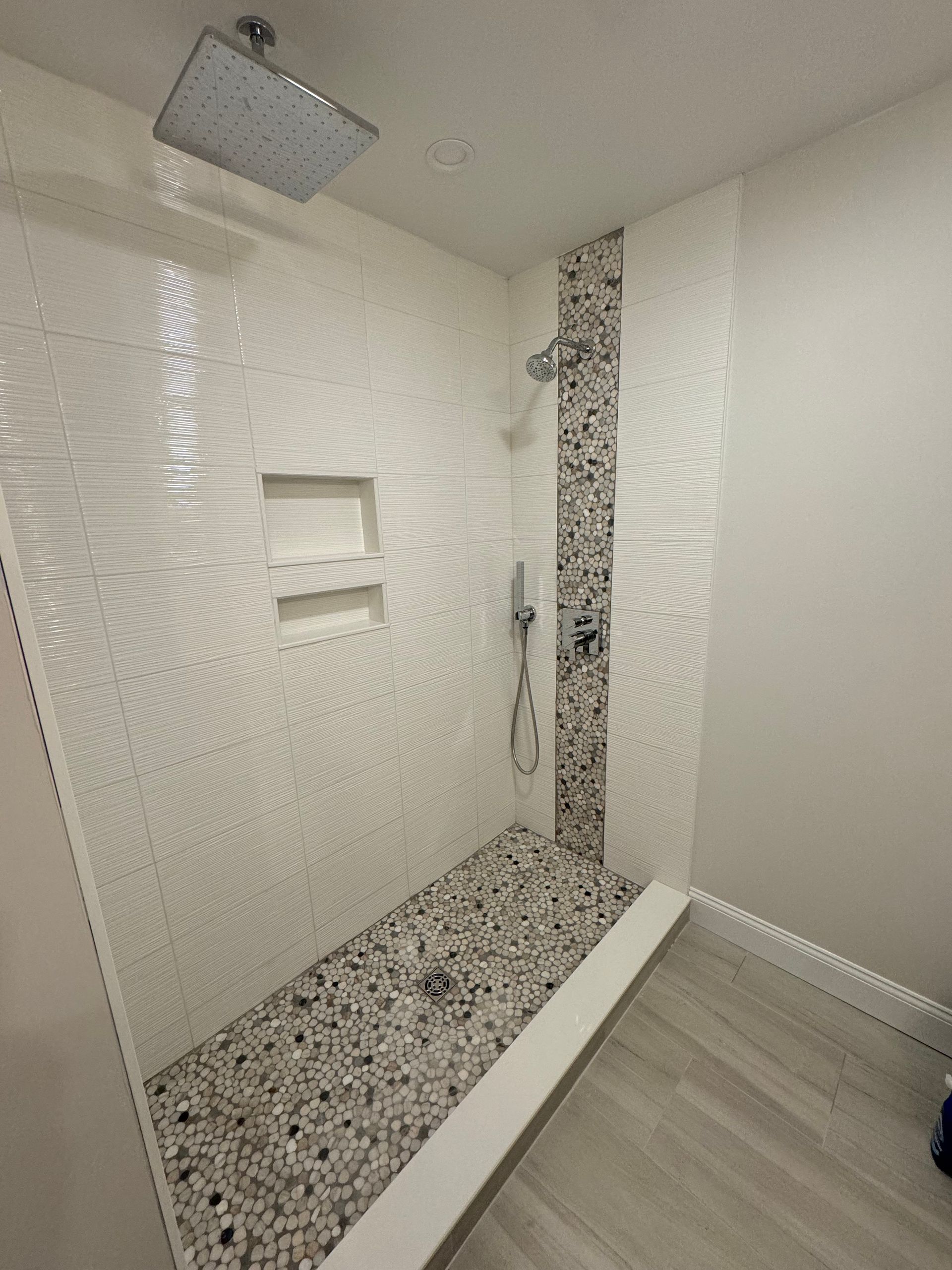 A bathroom with a walk in shower and a shower head.