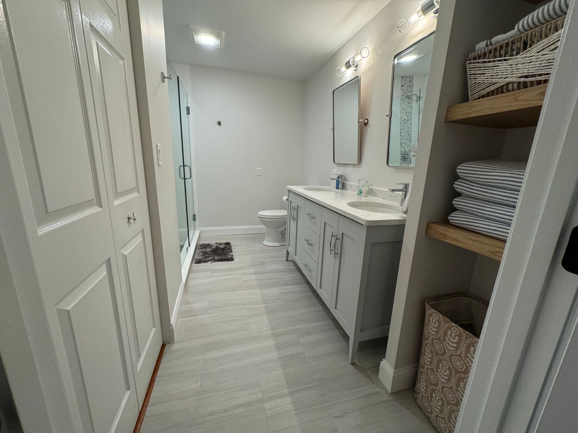 A bathroom with two sinks , a toilet , and a mirror.