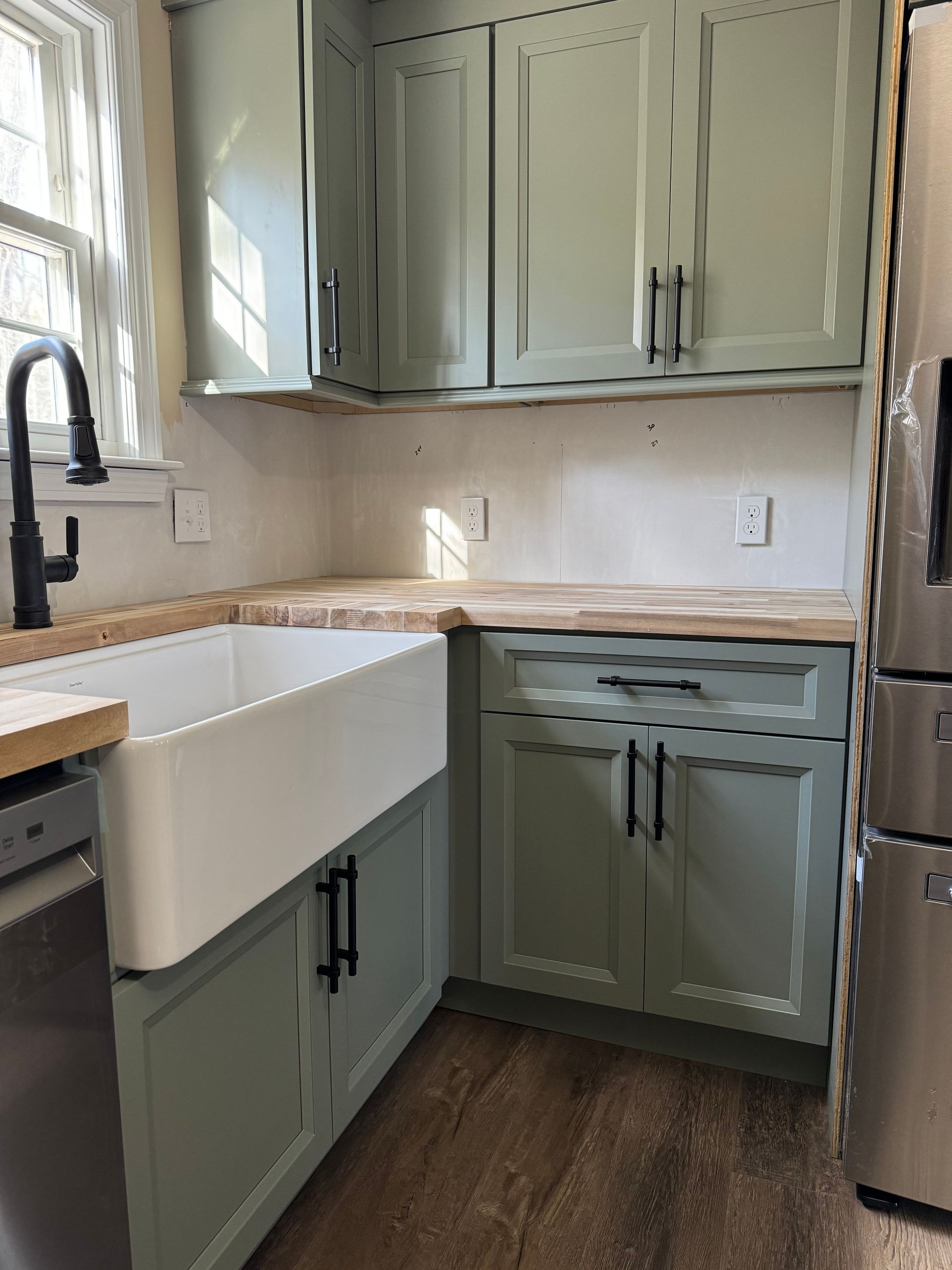 A kitchen with a sink , refrigerator , dishwasher , and stainless steel appliances.