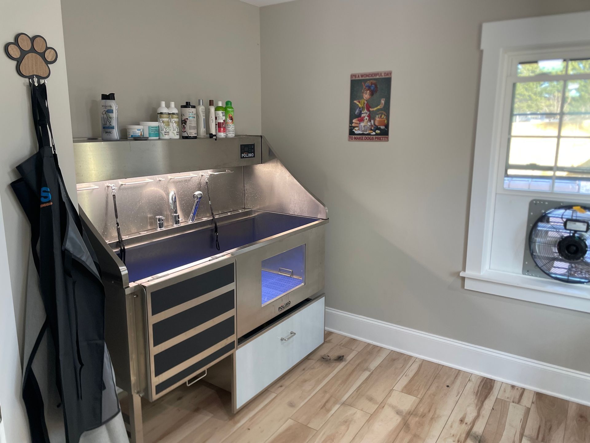 Dog grooming station in a corner with a window and a paw-shaped hanger.