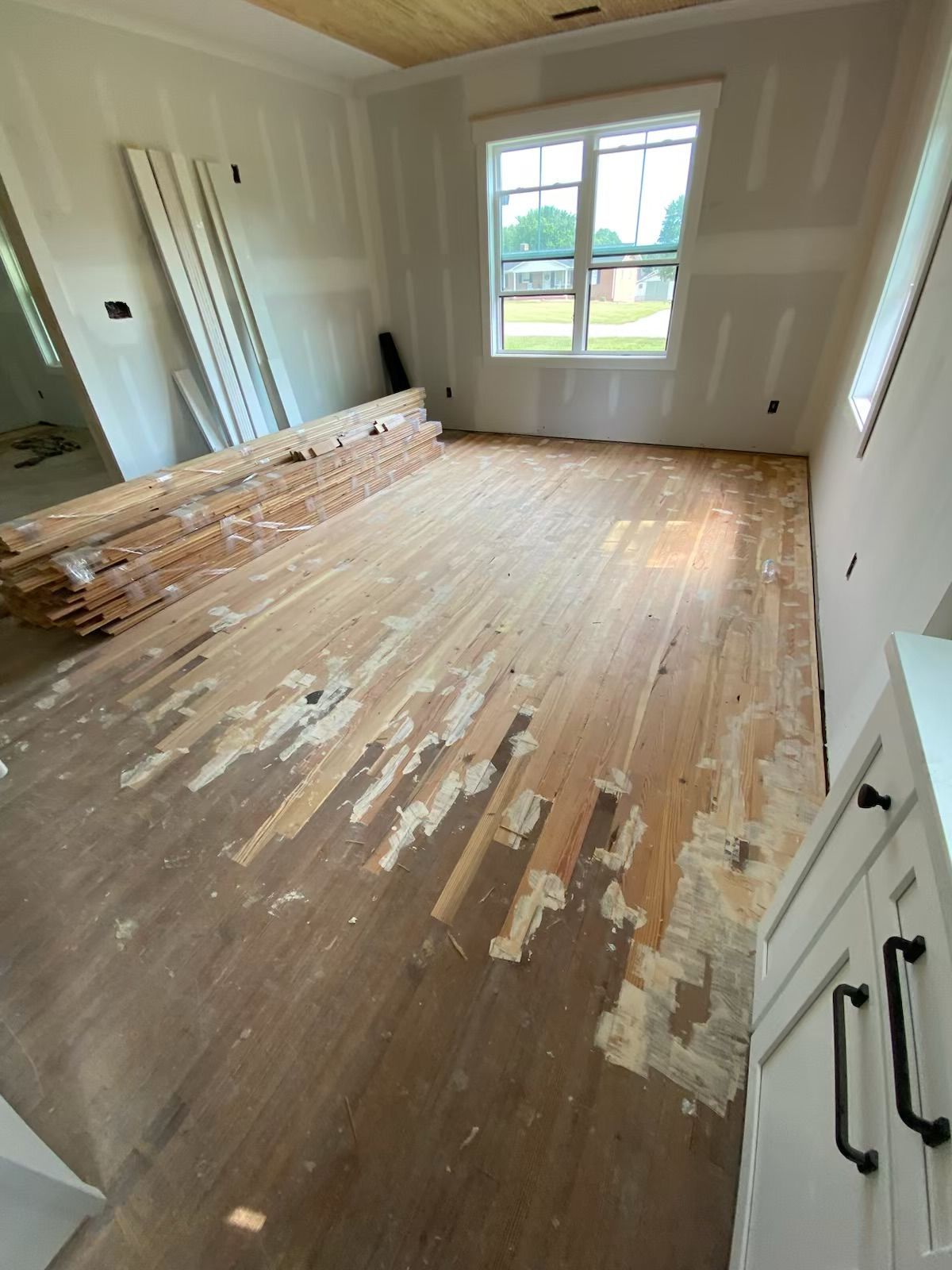An unfinished room with a wooden floor and a window