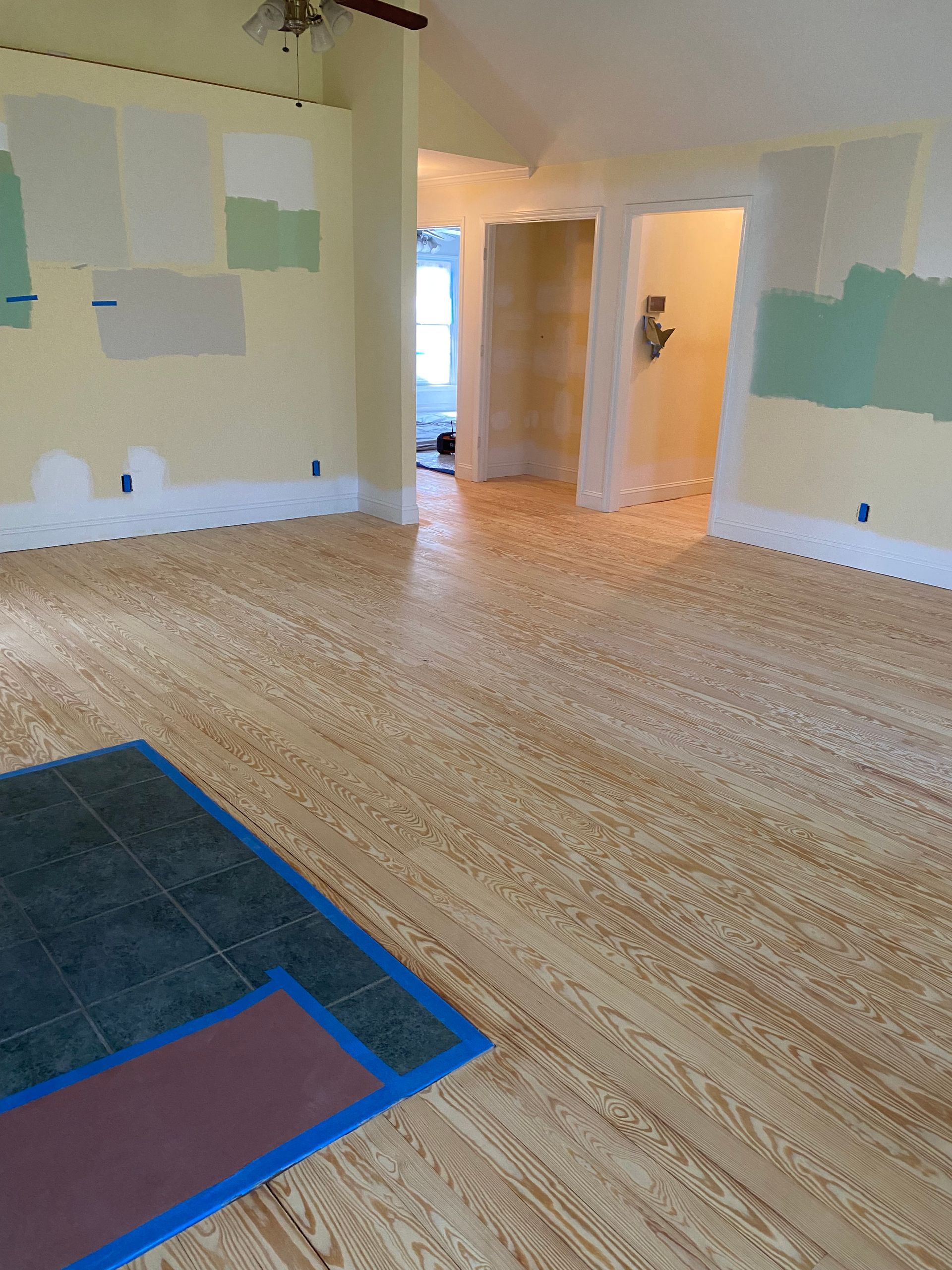 An empty room with a wooden floor and a tile floor.