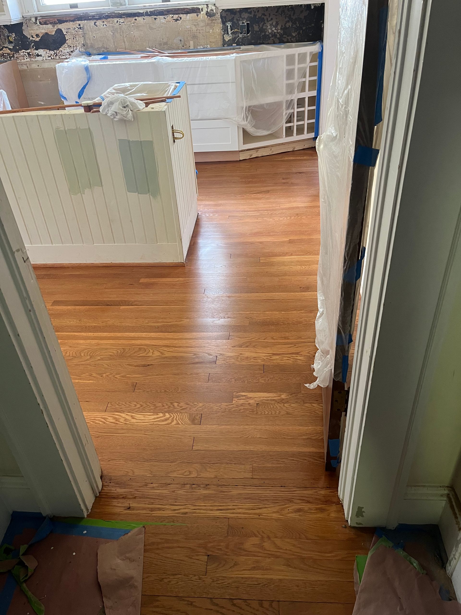 A kitchen with hardwood floors is being remodeled.