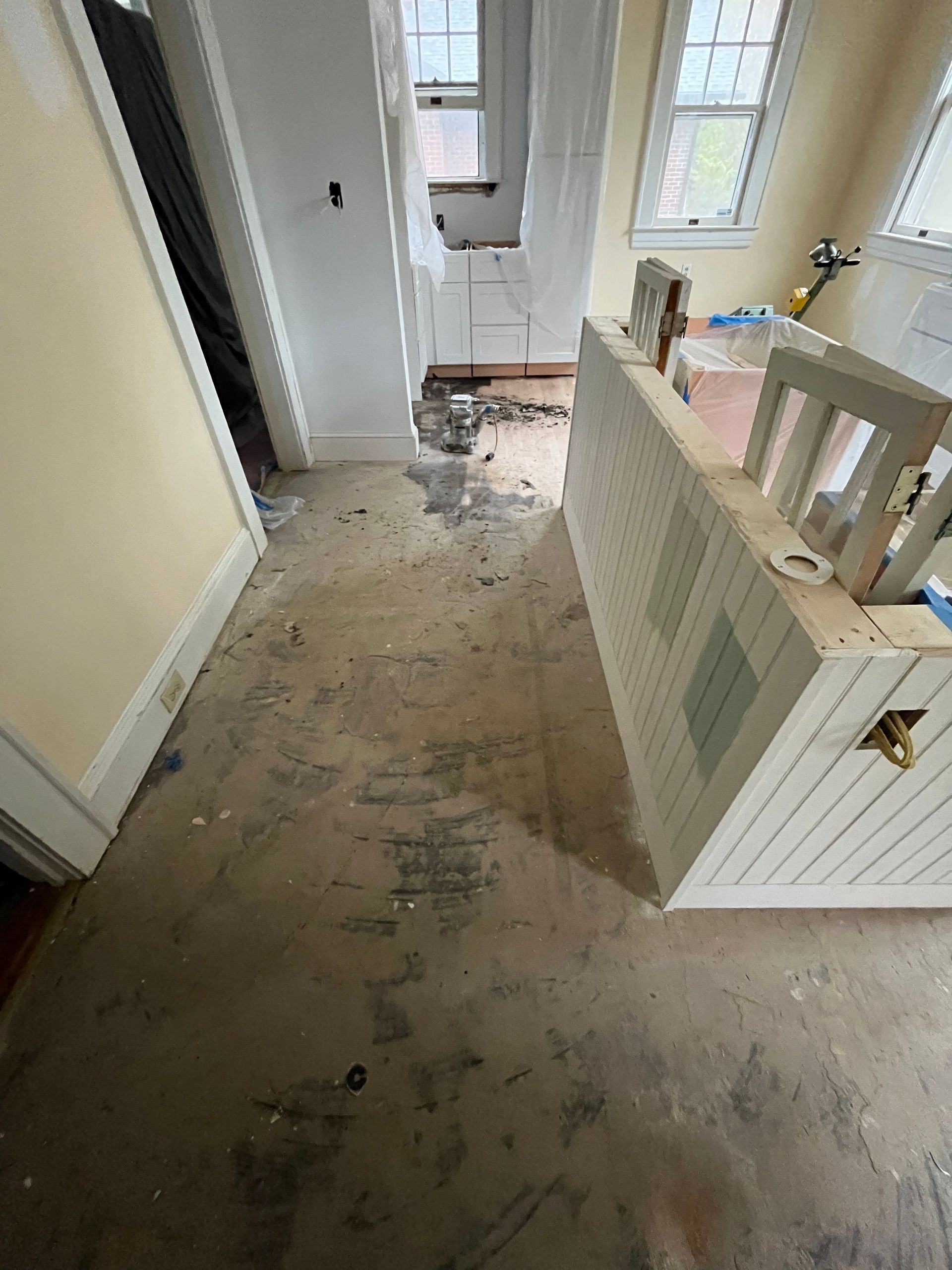 A room with a dirty floor and a white cabinet.