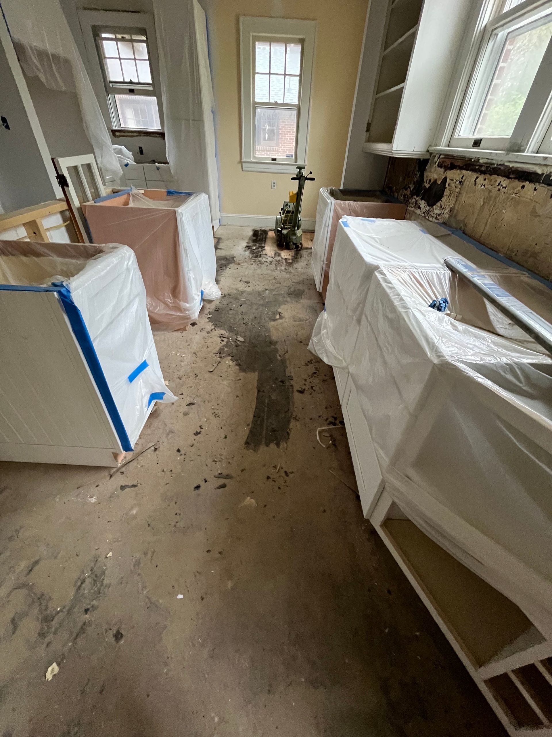 A kitchen under construction with a lot of trash on the floor.