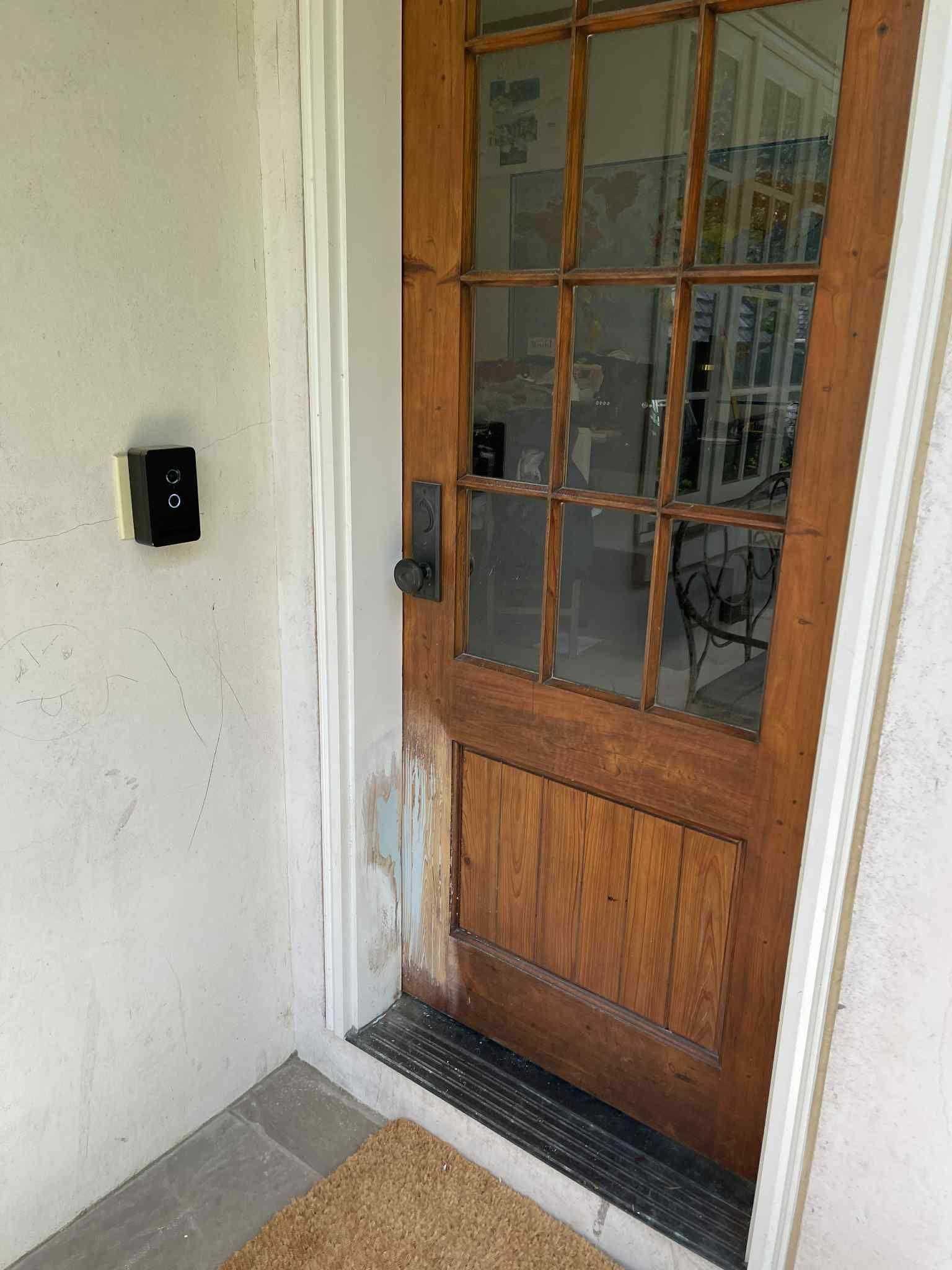 Wooden door with glass panes and a small doormat.