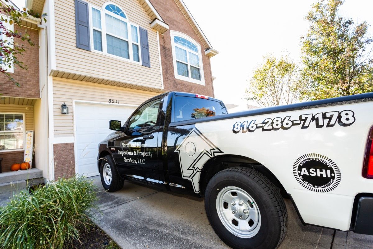A black and white truck is parked in front of a house.