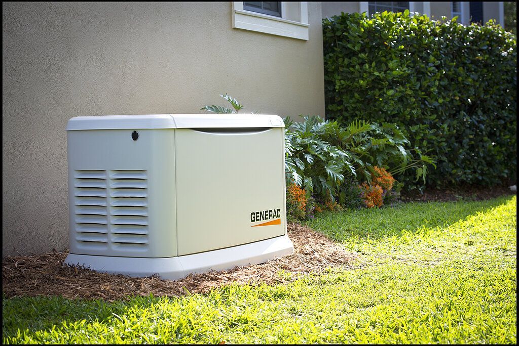 A generator is sitting in the grass next to a house.