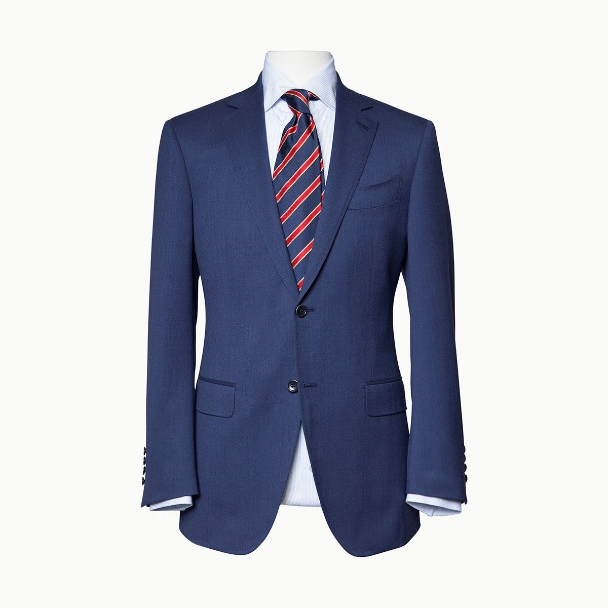 A dark blue suit jacket worn over a light blue collared shirt with a red and blue striped tie on a mannequin.