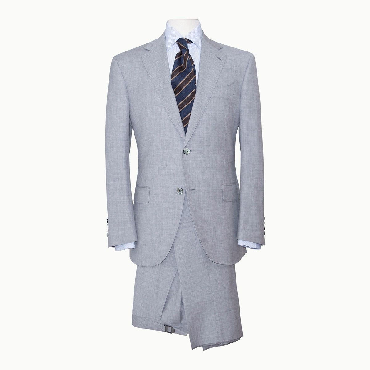 A light gray, patterned suit jacket paired with a matching skirt, a light blue collared shirt, and a dark striped tie.