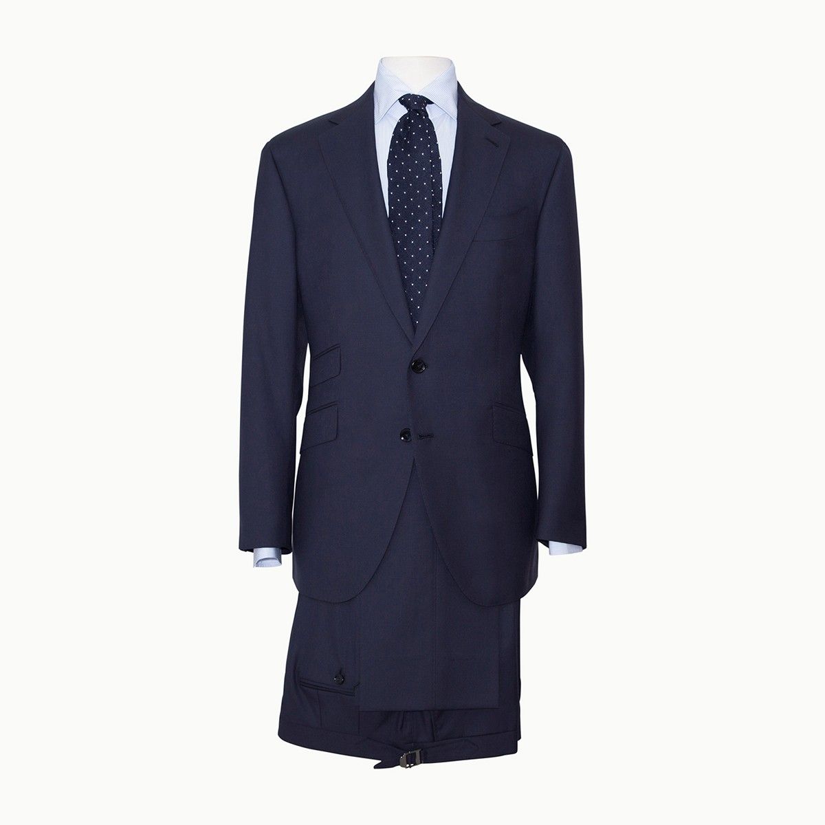 A dark blue suit jacket with a light blue button-down shirt and a navy tie with small white patterns on a white background.