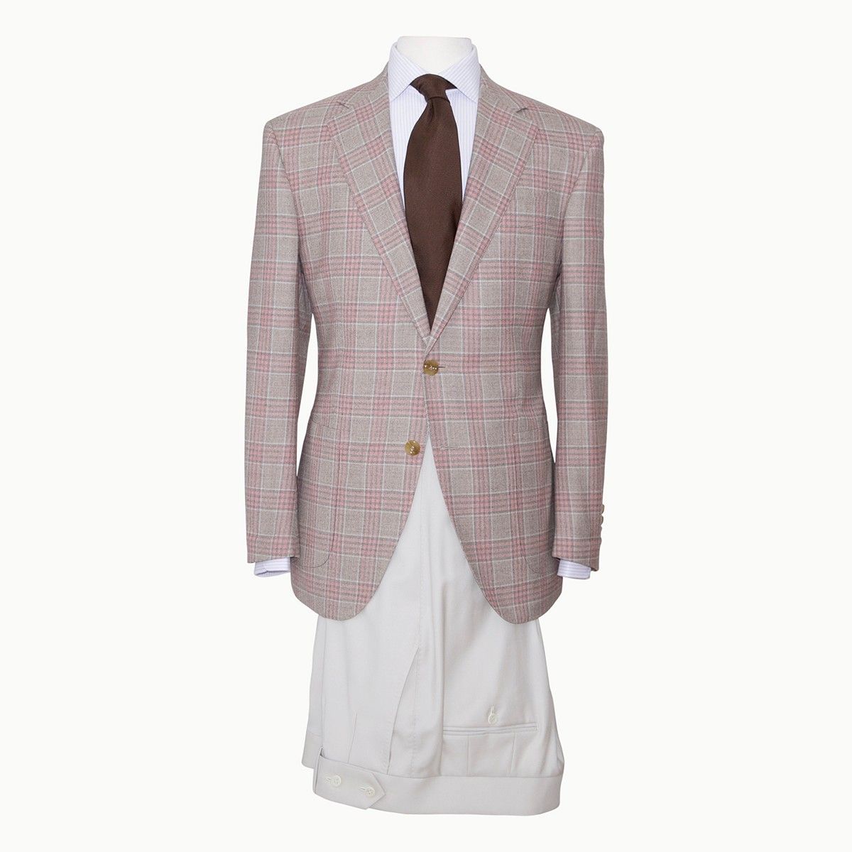 A beige plaid sport coat, white button-down shirt, brown tie, and white pleated trousers on a mannequin.