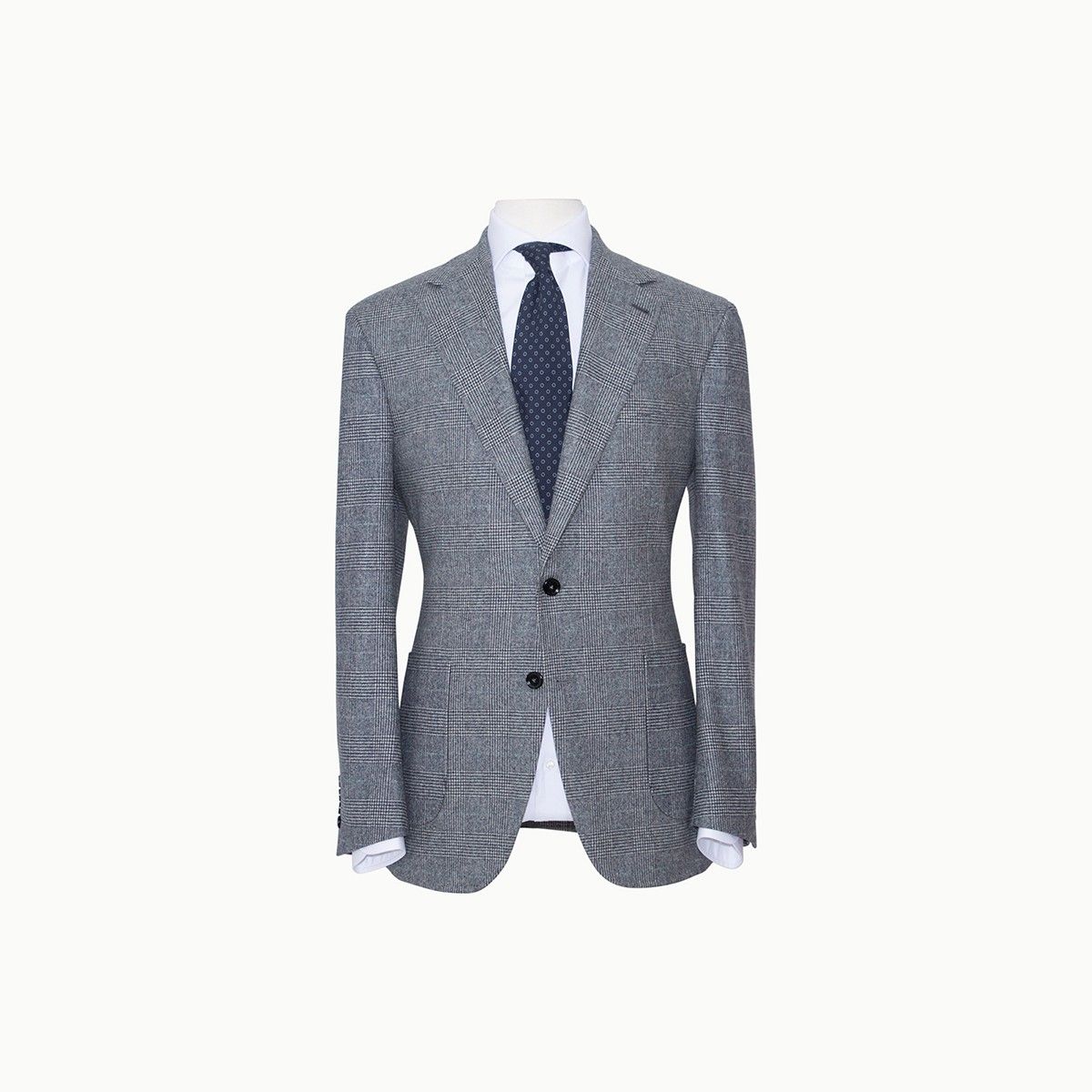 A grey plaid blazer worn over a white dress shirt and a dark, patterned tie on a mannequin.