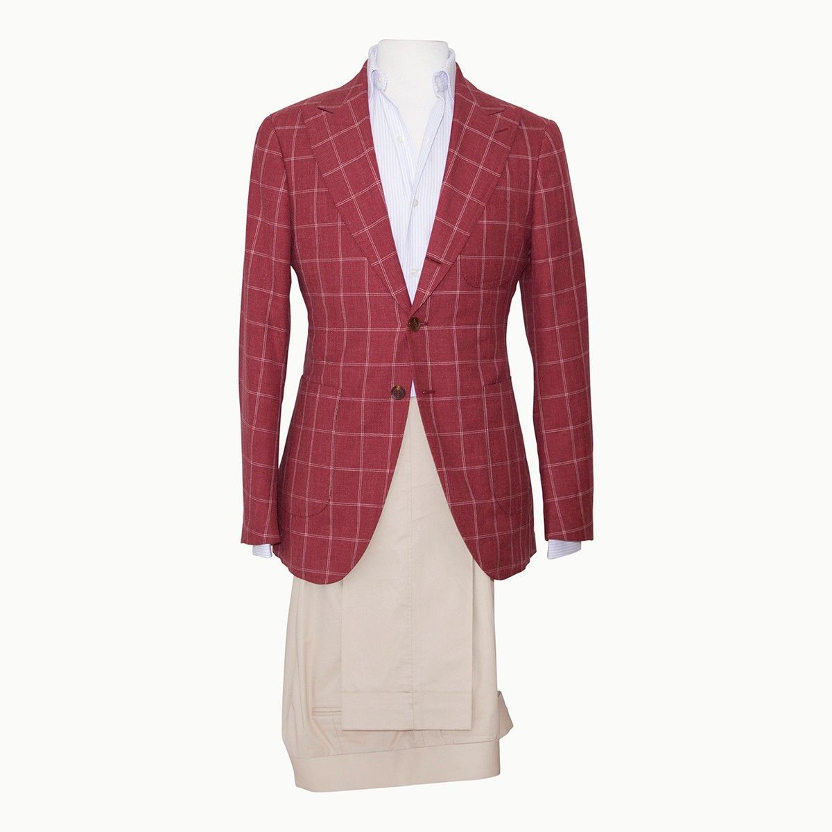 A red windowpane check blazer, white button-down shirt, and light beige trousers displayed on a mannequin torso.