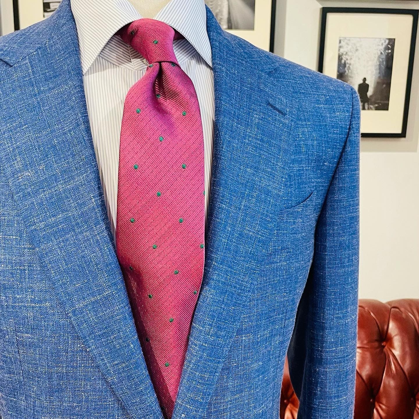 A textured blue blazer, light pinstriped shirt, and pink tie with small green polka dots.