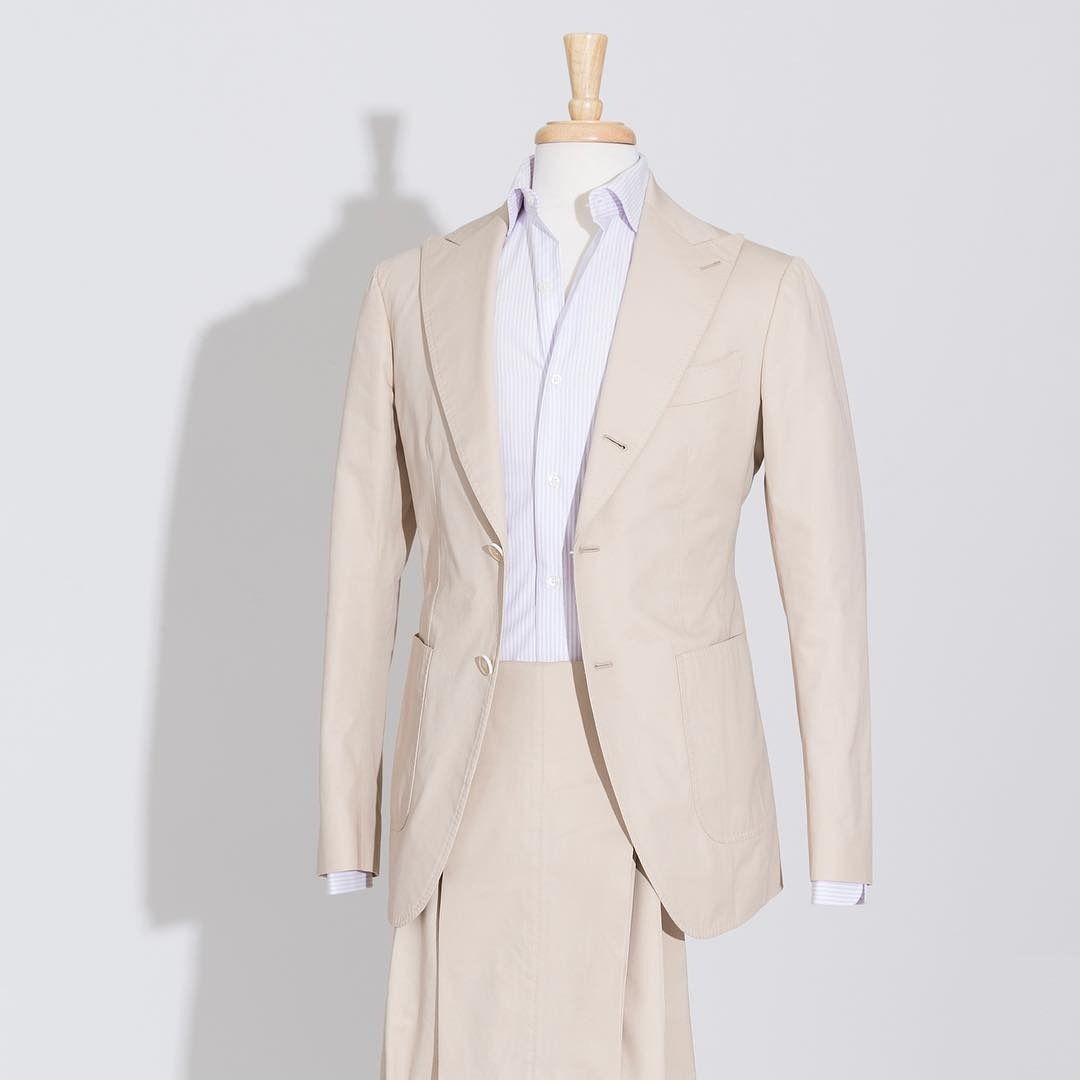 A light beige suit jacket worn over a white dress shirt, displayed on a mannequin against a plain light gray background.
