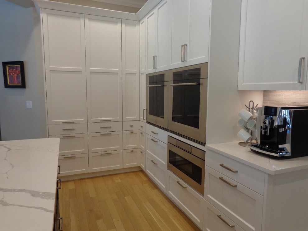 A kitchen with white cabinets and stainless steel appliances.