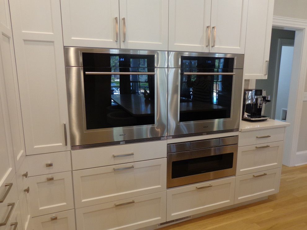 A kitchen with white cabinets and stainless steel appliances.