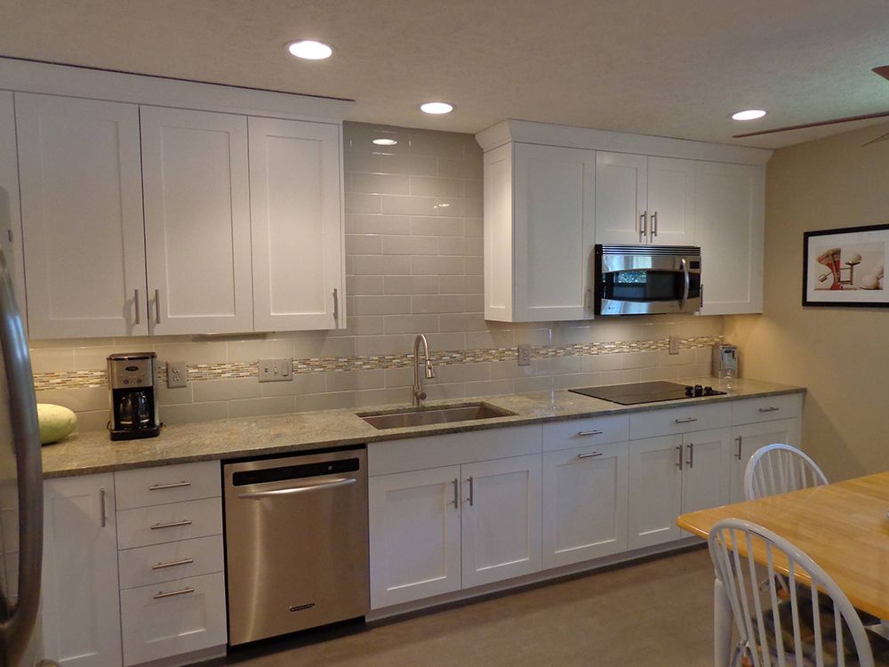 A kitchen with white cabinets and stainless steel appliances.
