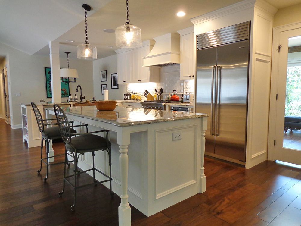 A kitchen with a large island and stools.