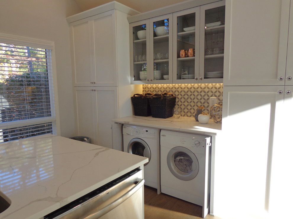 A laundry room with a washer and dryer and a sink.
