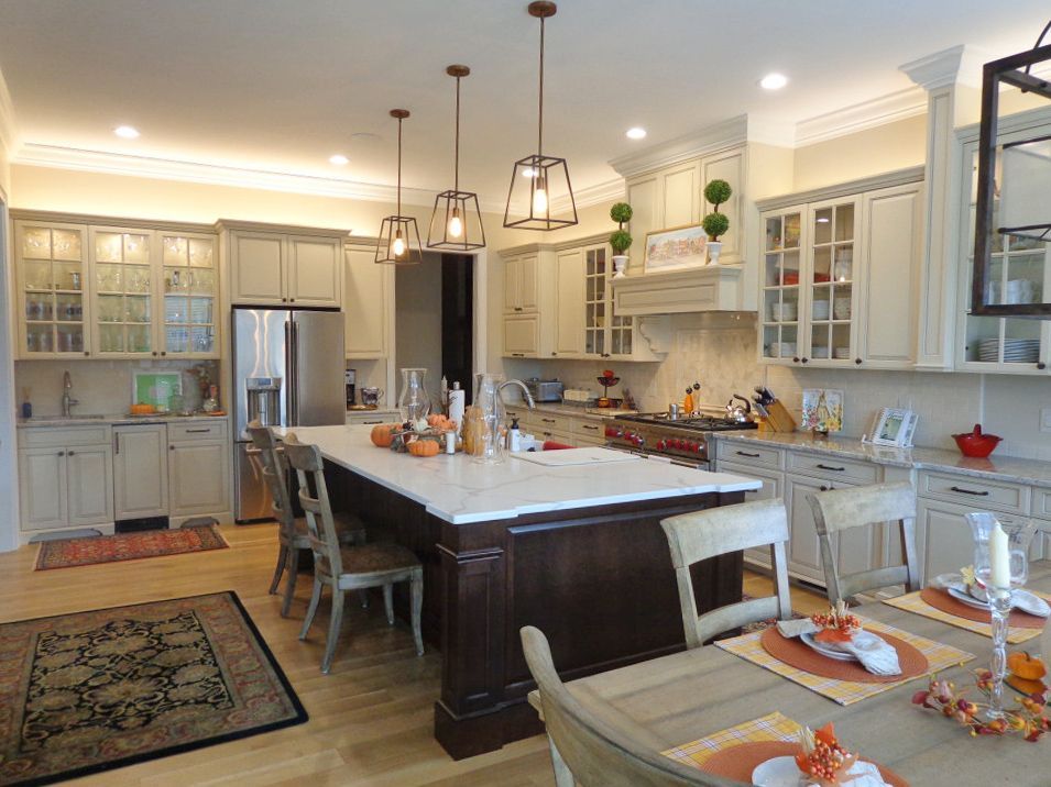 A kitchen with white cabinets and a large island in the middle.