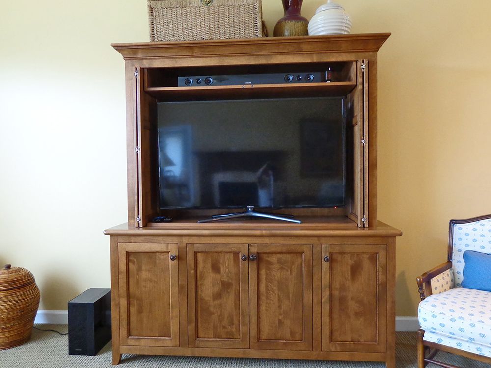 A wooden entertainment center with a flat screen tv in it.