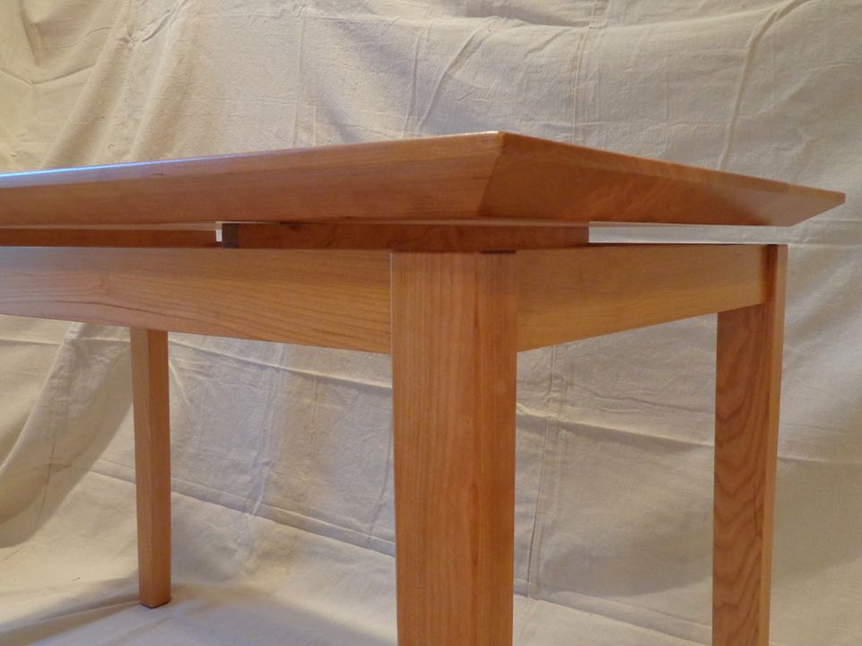 A small wooden table is sitting on a white cloth.