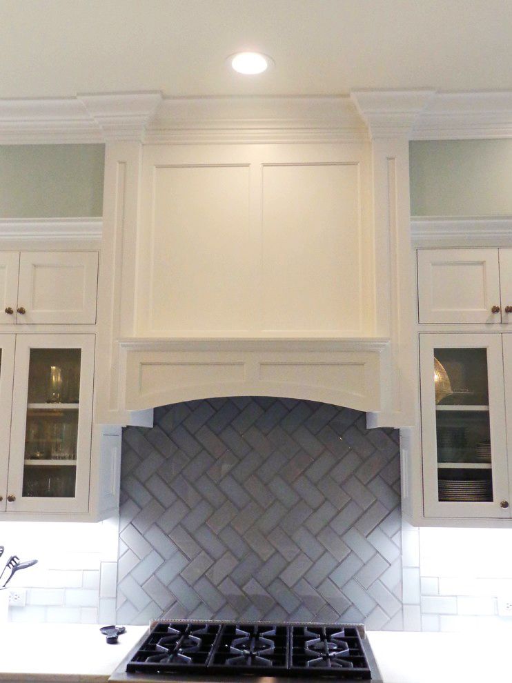 A kitchen with white cabinets and a stove top oven.
