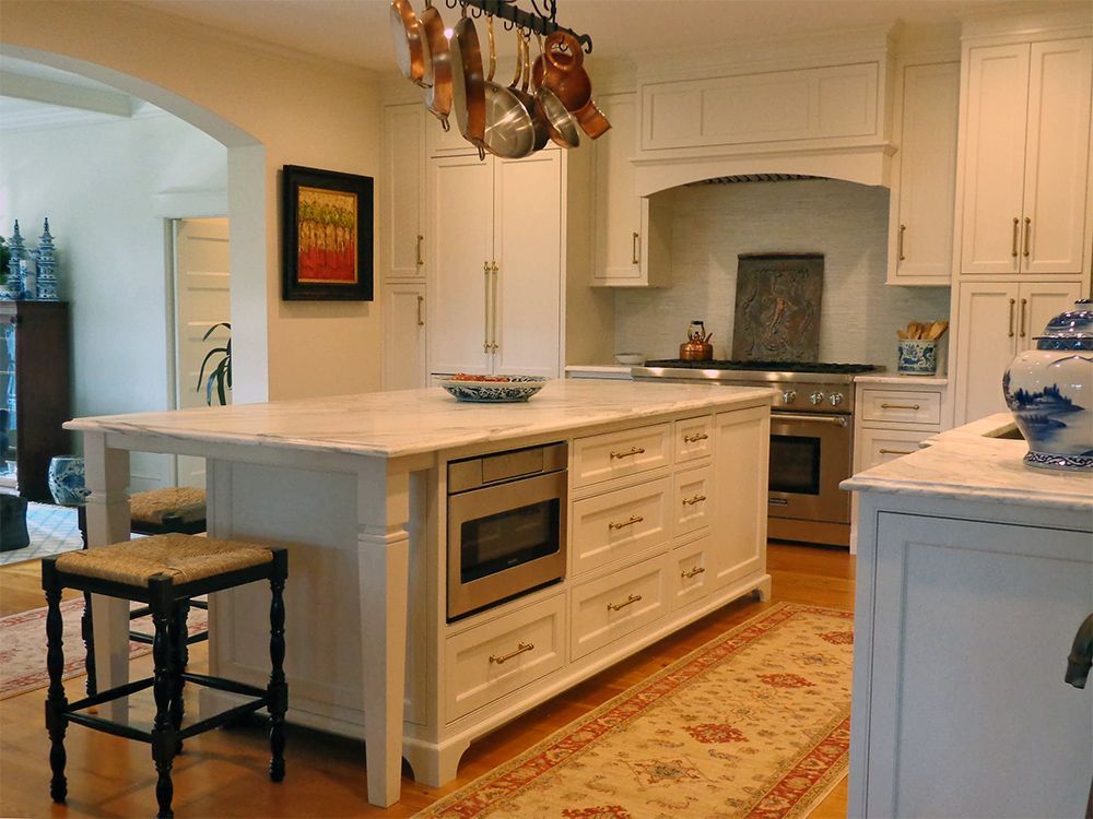 A kitchen with white cabinets and a large island.