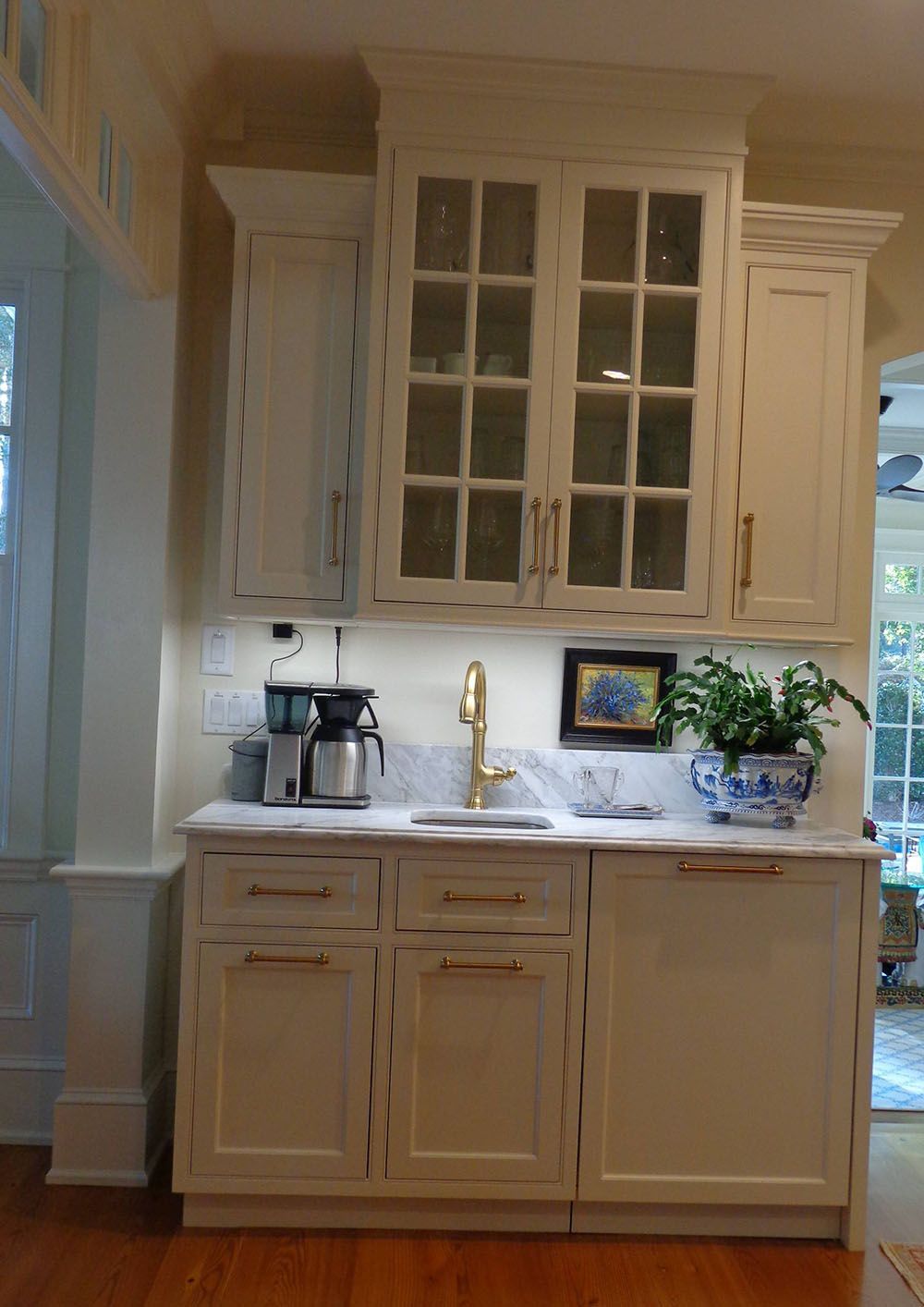 A kitchen with white cabinets and a sink.