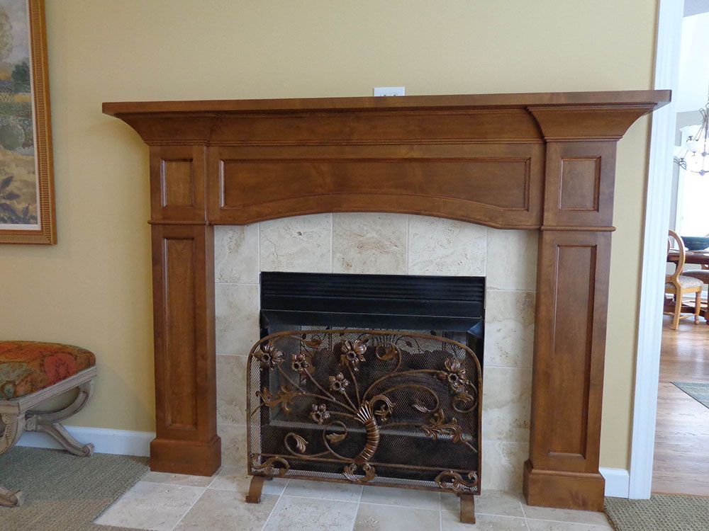 A fireplace with a wooden mantel in the living room.