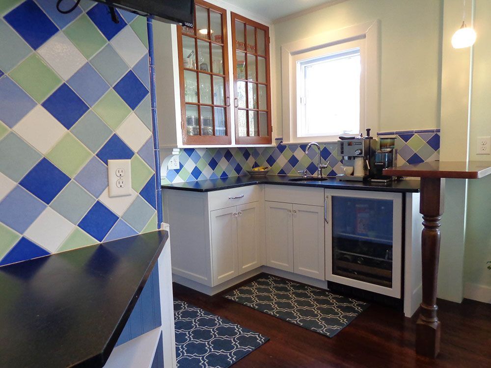 A kitchen with blue and green tiles on the walls.