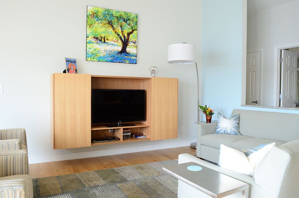 A living room with a couch and a flat-screen TV.