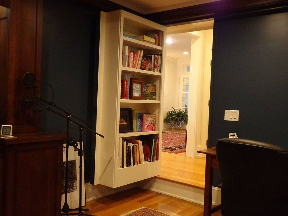 A room with a bookshelf and a desk and chair.