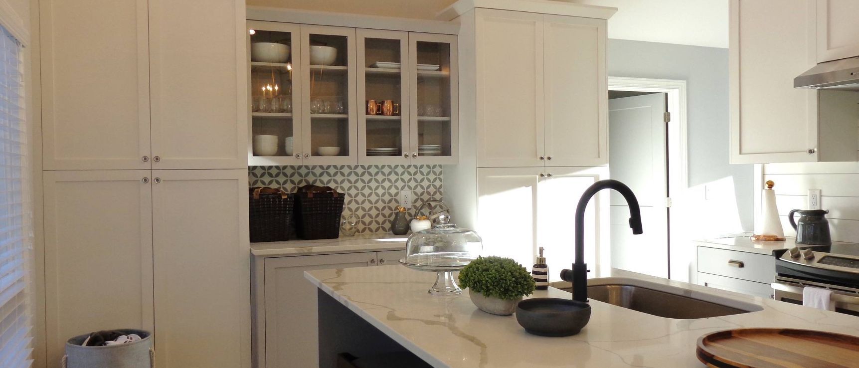 A kitchen with white cabinets and a black sink.