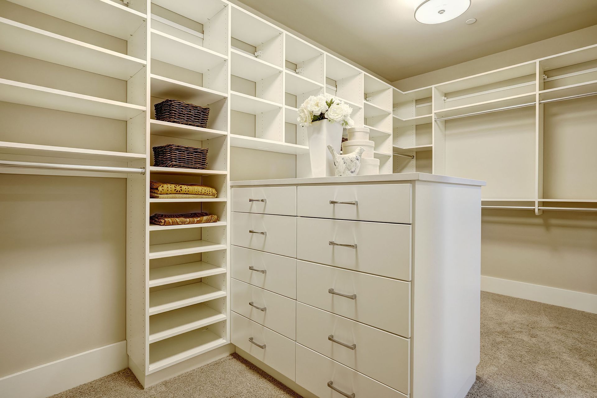 A walk in closet with lots of shelves and drawers.