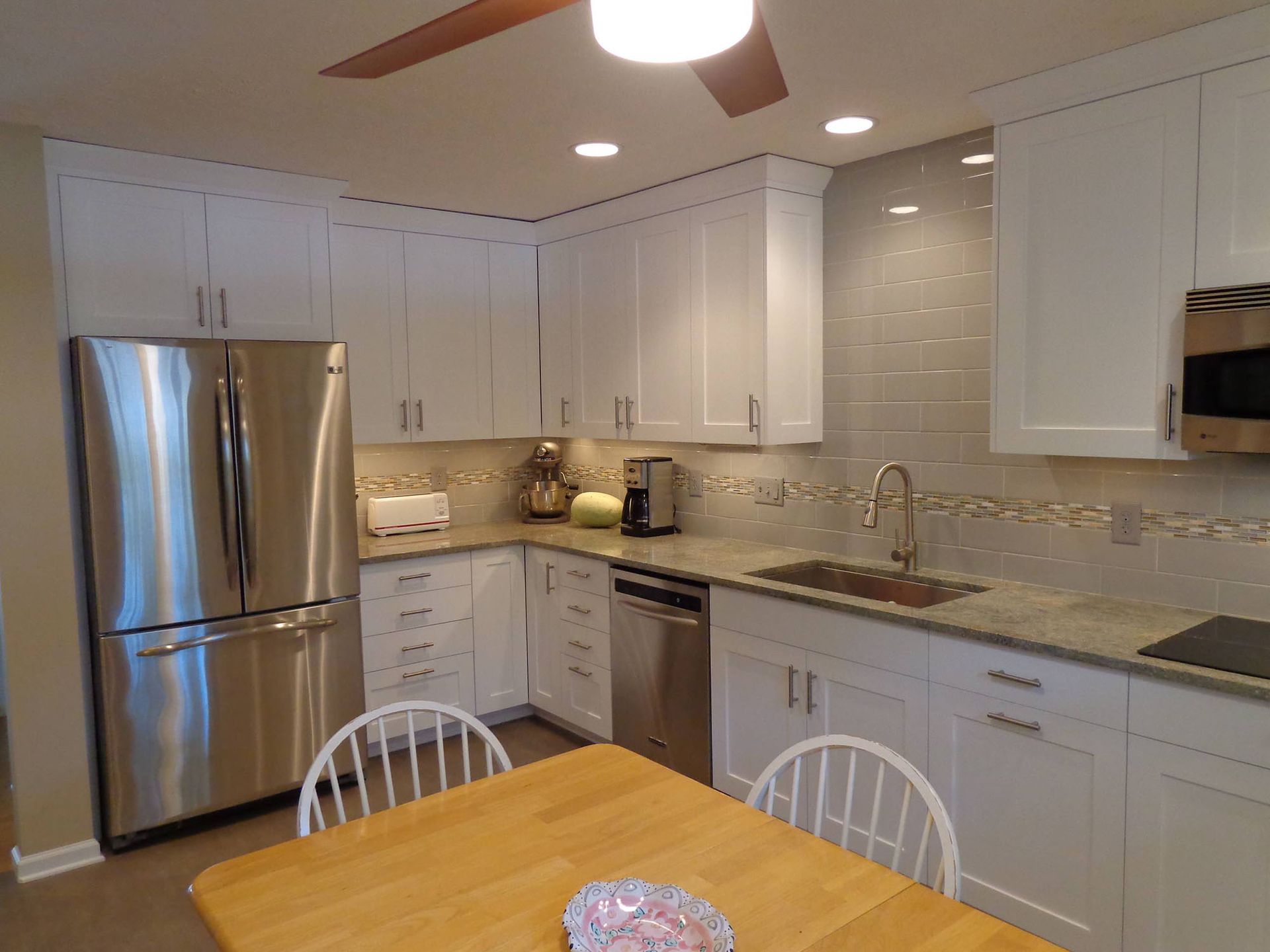 A kitchen with white cabinets and stainless steel appliances