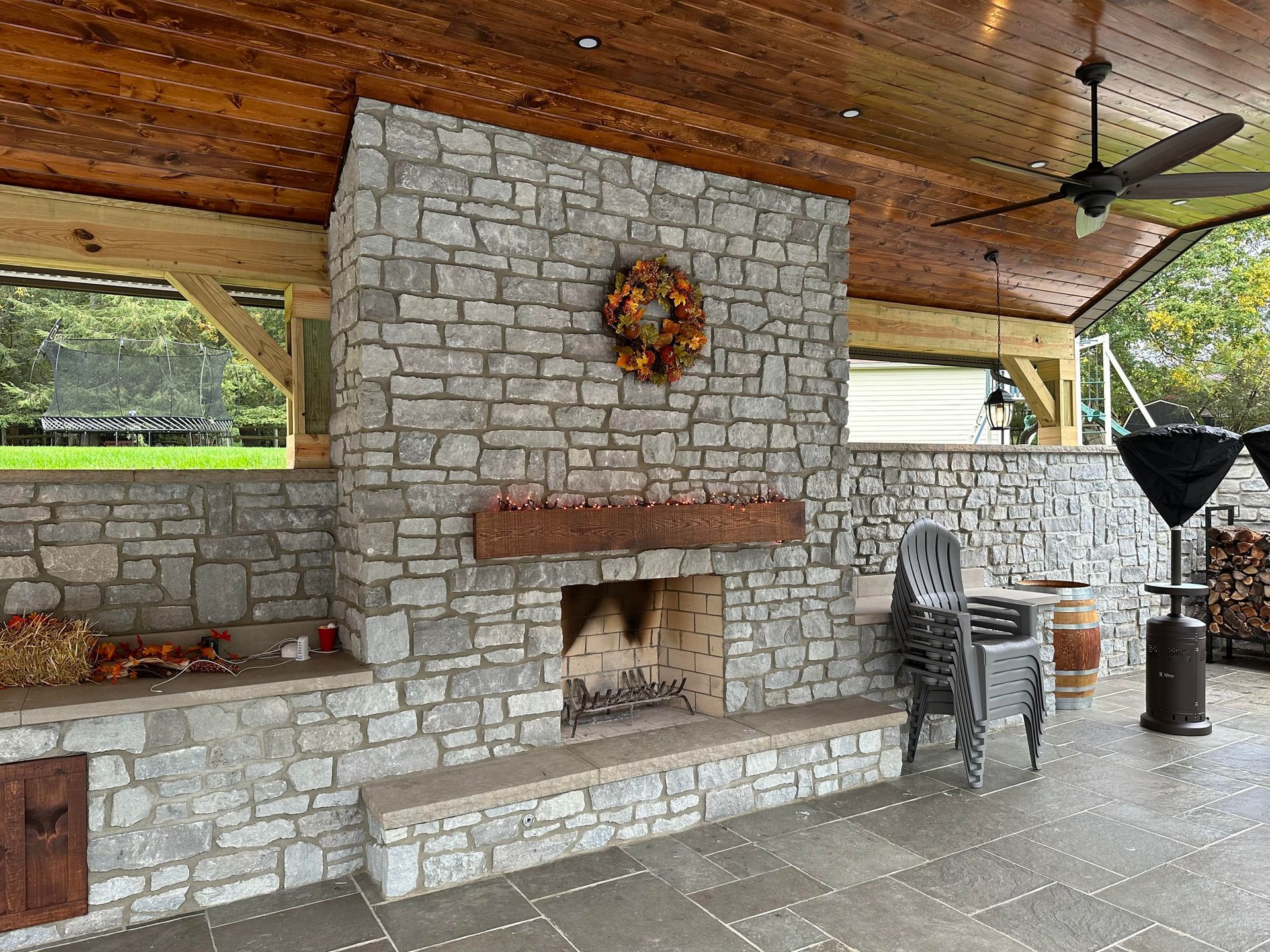There is a large stone fireplace in the middle of the room.